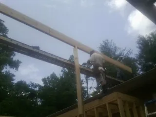 Carpenter setting a ridge beam over a new addition frame — Ice Dam Removal by Roofing Brothers in Larned
