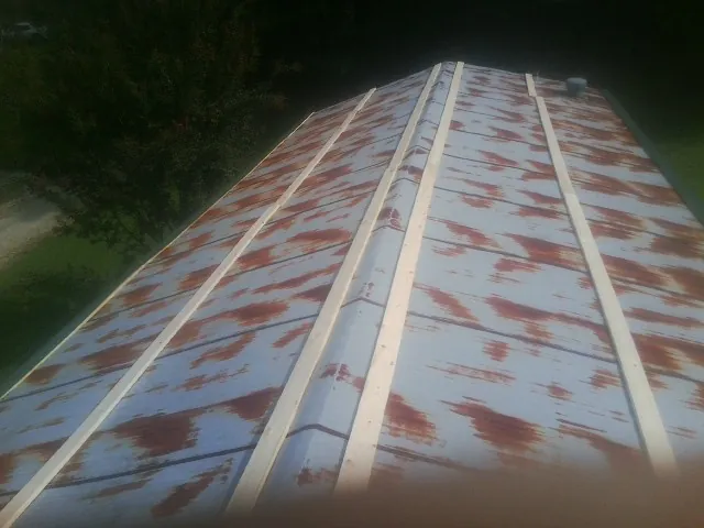Rusted metal roof panels with new wood purlins before replacement — Storm Damage Roof Repair in Larned by Roofing Brothers