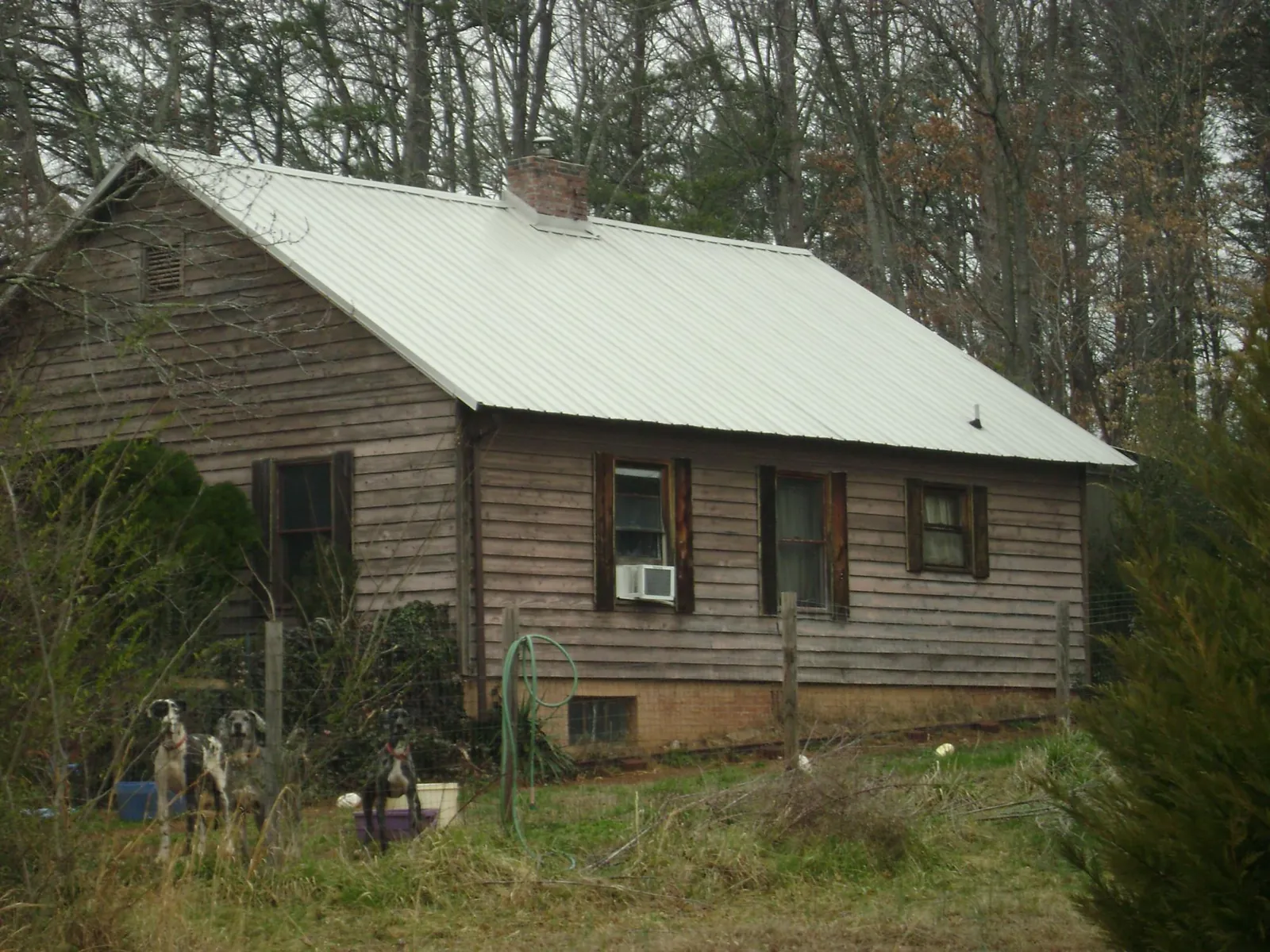 White metal roof on an old wood sided farmhouse, from a Metal Roof Installation job in Larned